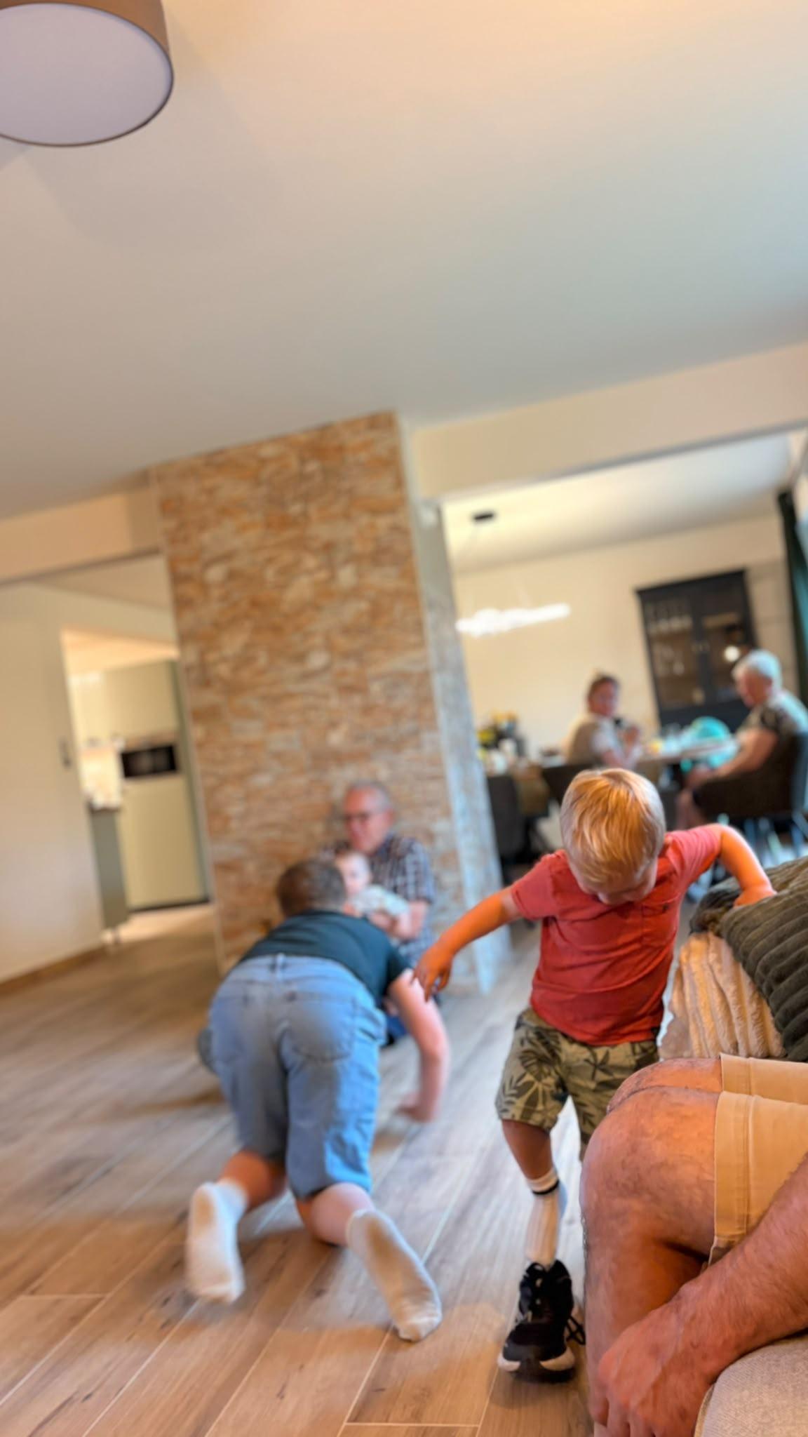 Kinderen spelen in de woonkamer van Maison Campagnard