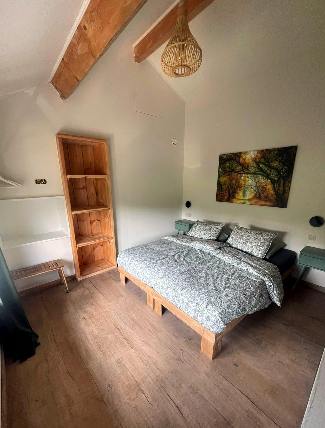 Slaapkamer met houten balken en tweepersoonsbed in Maison Campagnard, Teuven