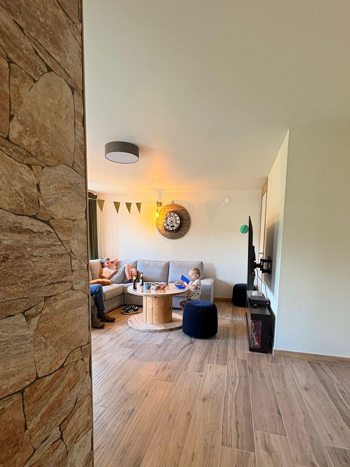Zithoek van de woonkamer achter de natuurstenen scheidingsmuur, vakantiewoning Maison Campagnard in Teuven