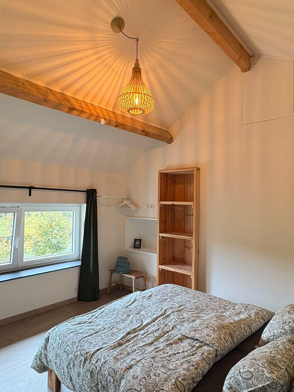 Chambre à l'étage avec poutres en bois, suspension en osier et armoire ouverte en bois, maison de vacances Maison Campagnard à Teuven