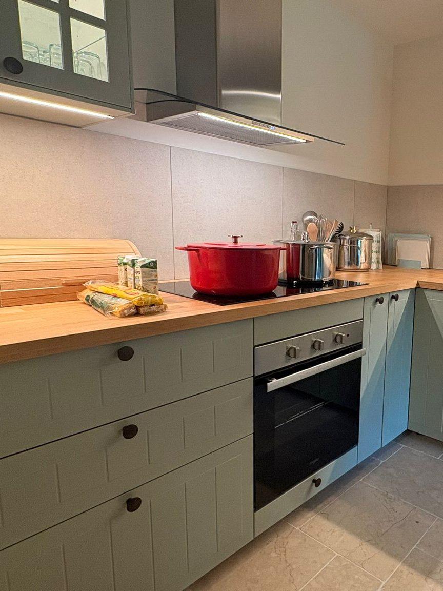 Keuken met oven, inductiekookplaat en houten werkblad in Maison Campagnard, Teuven