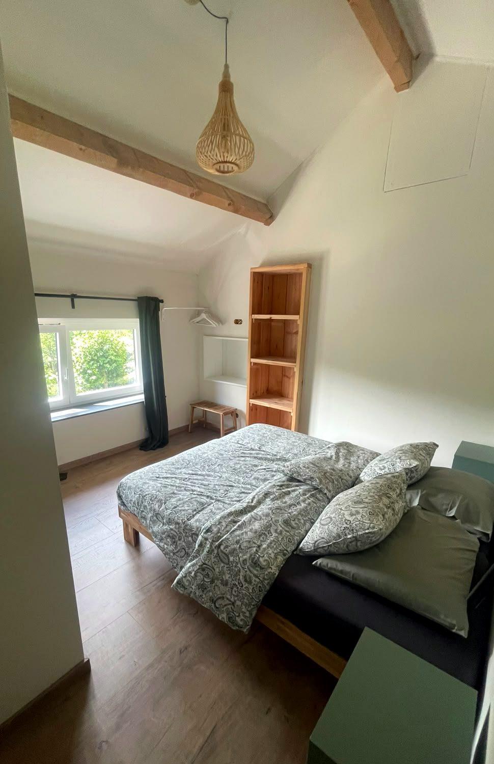 Slaapkamer boven met houten balken en open kastruimte, vakantiewoning in de Voerstreek